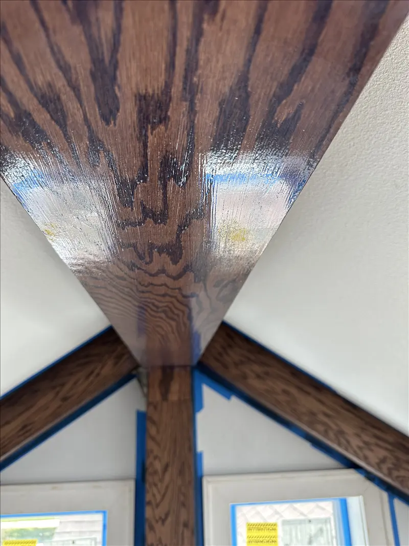 Stained wood beams meeting at a vaulted ceiling with clean edges